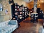 Vista general del interior de la librería con zona de sofás y estanterías oscuras