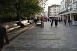 Zona peatonal de New Road en Brighton con bancos y árboles
