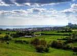 Vista panorámica de los campos verdes de East Brighton Park con el mar de fondo
