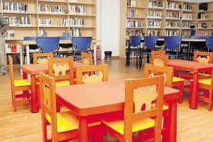 Sala infantil de la biblioteca con mesas y sillas de colores