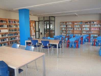 Sala de lectura con estanterías y mesas para estudio