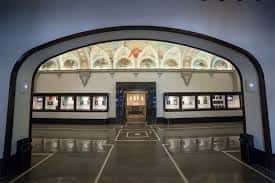 Hall de entrada con arco decorado y vitrinas de exposición