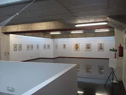 Interior de una sala de exposiciones con obras colgadas en las paredes