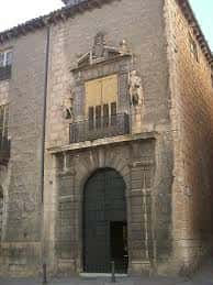 Fachada histórica del edificio principal de la plaza, con puerta arqueada y balcón decorado
