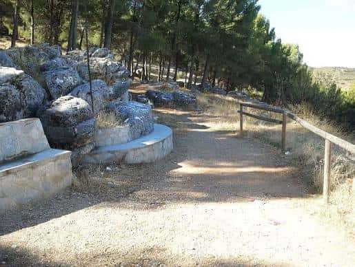 Área de descanso con bancos de piedra y sendero natural