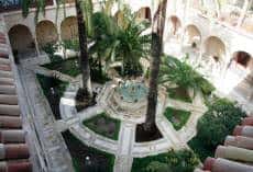 Patio interior con palmeras y arcos coloniales