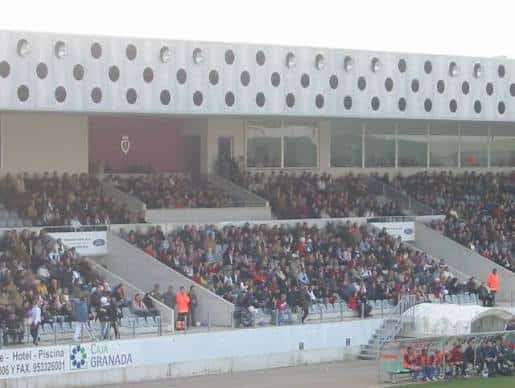 Tribuna principal del estadio con espectadores y diseño arquitectónico distintivo