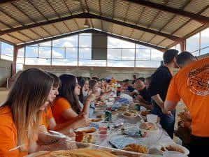 Comida compartida en mesa larga durante reunión social de Peña Escopitos