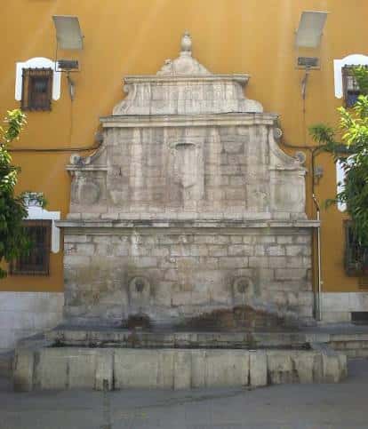 Fuente del Pilar del Arrabalejo en Jaén con fondo de edificio amarillo