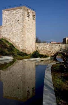 Torreón del Alamín reflejado en el agua con cielo azul