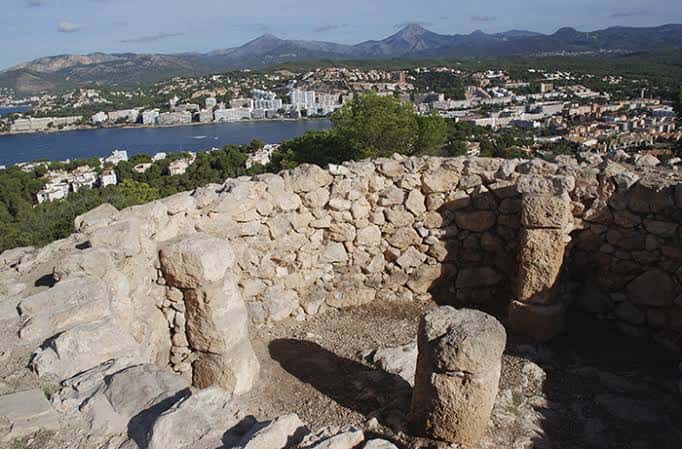 Detalle de las ruinas de piedra con vista a la ciudad y el puerto