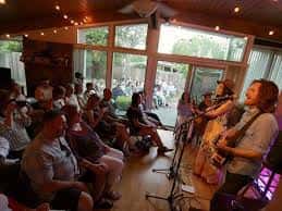 Concierto íntimo en casa con músicos tocando para una audiencia sentada