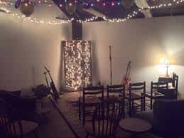 Sala preparada para un concierto privado con luces de hadas y sillas dispuestas