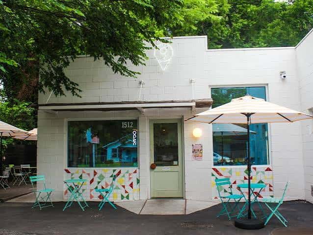 Fachada exterior de Gati Cafe con decoración geométrica colorida y mesas al aire libre