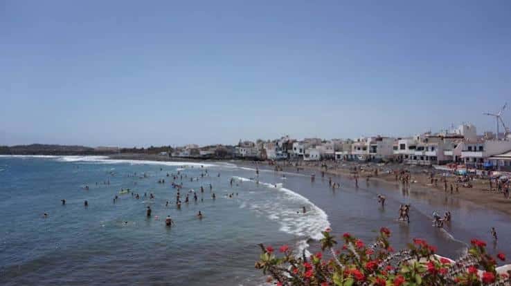 Vista panorámica de la Playa de Ojos de Garza con bañistas y el casco urbano al fondo