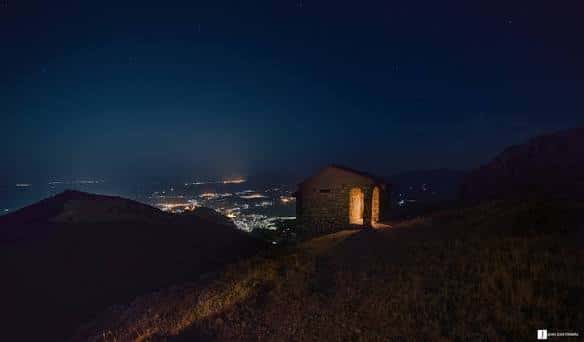 Refugio de la Mella iluminado por la noche con vistas a la ciudad