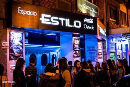 Fachada nocturna de la Sala Estilo en Oviedo con iluminación azul y letrero luminoso