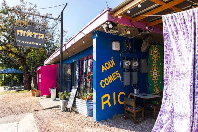 Fachada exterior colorida de Nixta Taqueria con letrero y decoración vibrante