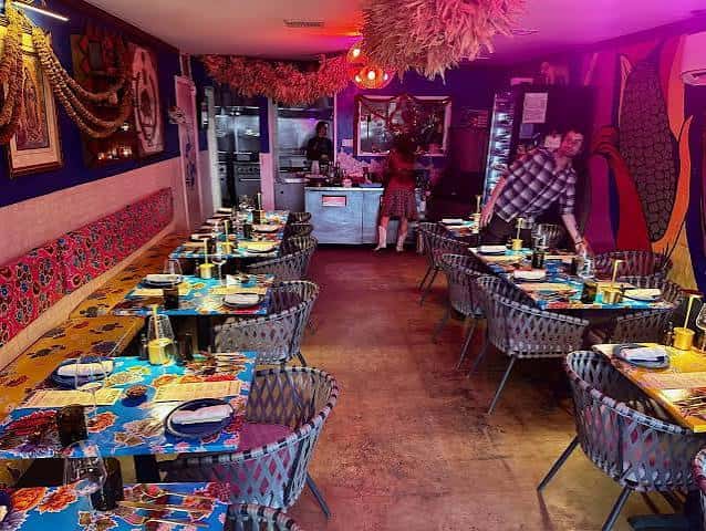 Interior del restaurante con mesas decoradas, iluminación cálida y ambiente festivo