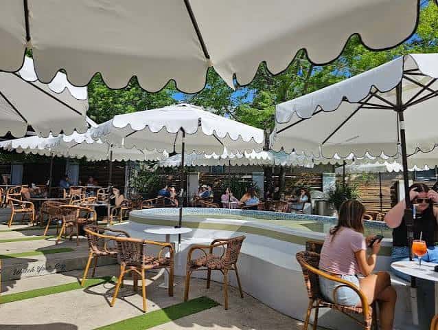 Terraza exterior con piscina y sombrillas blancas