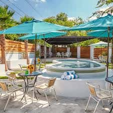 Área de piscina al aire libre con sombrillas turquesa