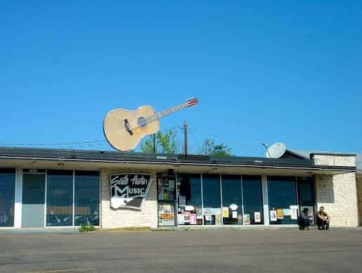 Fachada exterior de South Austin Music con su icónica guitarra en el techo