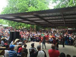 Vista general del mercado al aire libre con una gran multitud de personas bajo un toldo