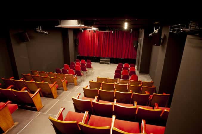Interior del auditorio de SalaLaPaca con butacas rojas y escenario