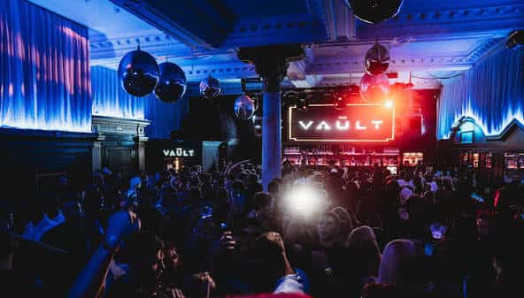 Interior del The Vault Nightclub con ambiente de fiesta y luces azules