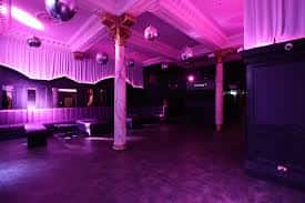 Sala principal del club vacía con iluminación púrpura y decoración elegante