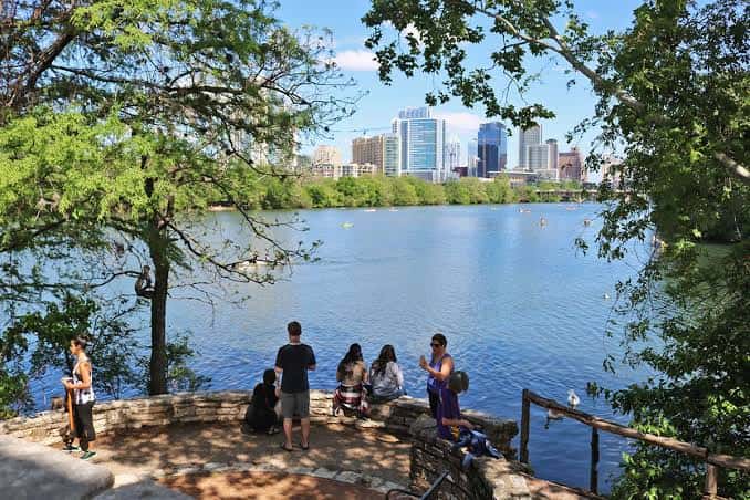 Grupo de personas disfrutando de la vista del horizonte urbano desde un mirador natural