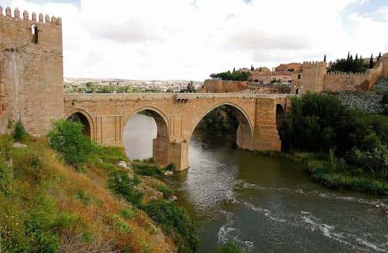 Vista panorámica del Puente de San Martín en Toledo durante el día con la ciudad al fondo