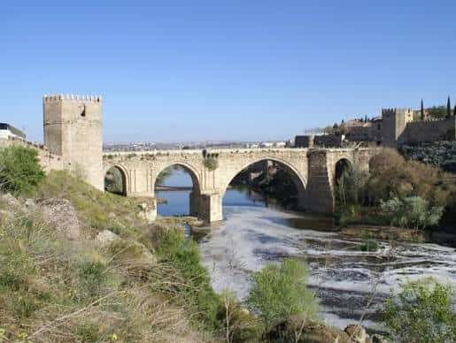 Puente de San Martín bajo un cielo azul despejado con vistas al río Tajo