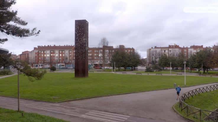 Torre de la Memoria en el centro del parque con fondo urbano