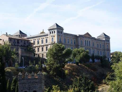 Fachada principal del edificio con detalles arquitectónicos y banderas en el balcón