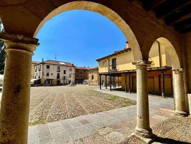 Plaza del Grano vista desde los arcos del pórtico bajo un cielo despejado
