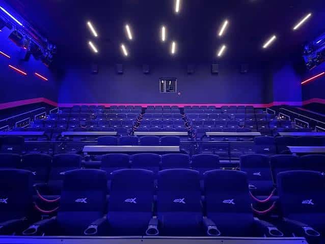 Sala de cine moderna con asientos reclinables y ambientación LED azul