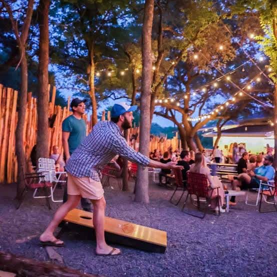 Juego de cornhole en el patio al aire libre durante la tarde-noche