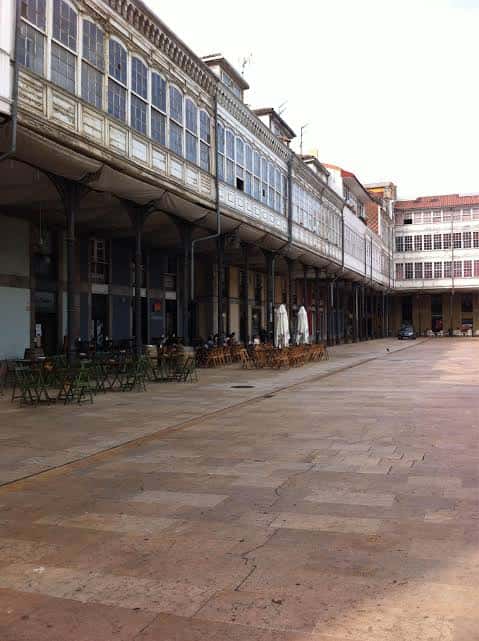 Plaza del mercado con mesas al aire libre y arquitectura histórica