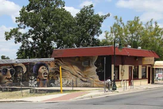 Vista exterior del Victory Grill con murales artísticos en la fachada