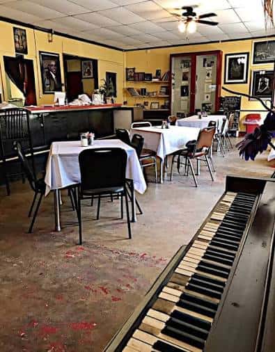 Interior del restaurante con mesas dispuestas y piano al frente