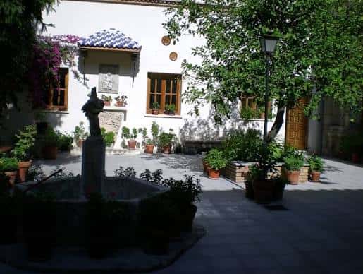 Patio ajardinado con fuente central y vegetación mediterránea