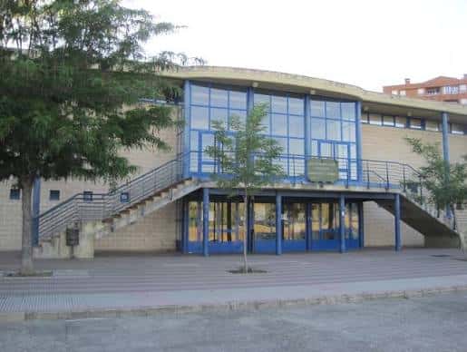 Vista exterior del Pabellón Margarita Ramos en León con fachada de ladrillo y detalles en azul