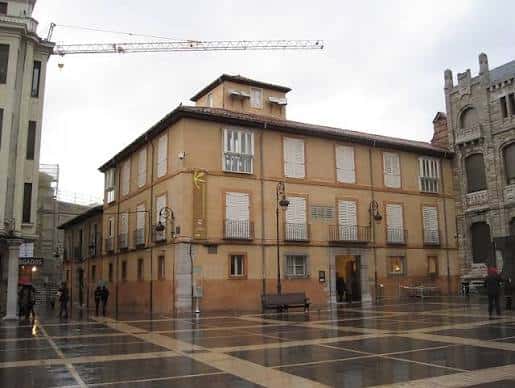 Vista general de la Plaza de Puerta Obispo con edificios históricos y suelo mojado