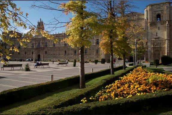 Vista diurna de la Plaza de San Marcos con el Convento iluminado por el sol y jardines floridos