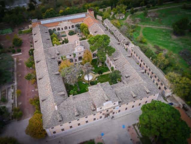Vista aérea del complejo de la Fábrica de Armas mostrando el patio central y los edificios históricos rodeados de vegetación