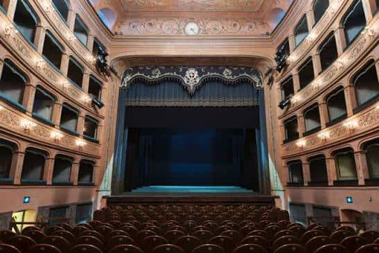 Vista general del auditorio del Teatro Rossini con butacas rojas y telón de fondo