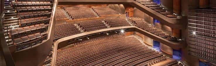 Vista panorámica del interior del auditorio con butacas de madera y balcones curvos
