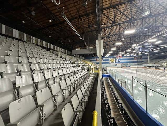 Interior del auditorio con gradas blancas y pista de hielo
