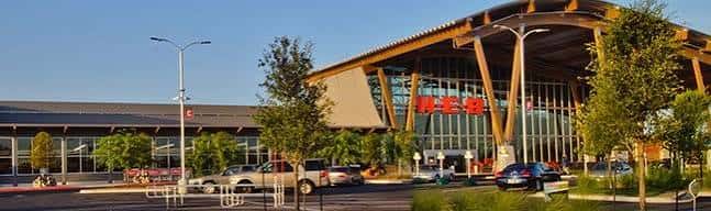 Vista exterior del H-E-B Mueller con diseño arquitectónico distintivo y estacionamiento